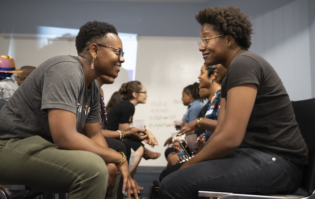 people sitting down and facing each other as if they are having a discussion