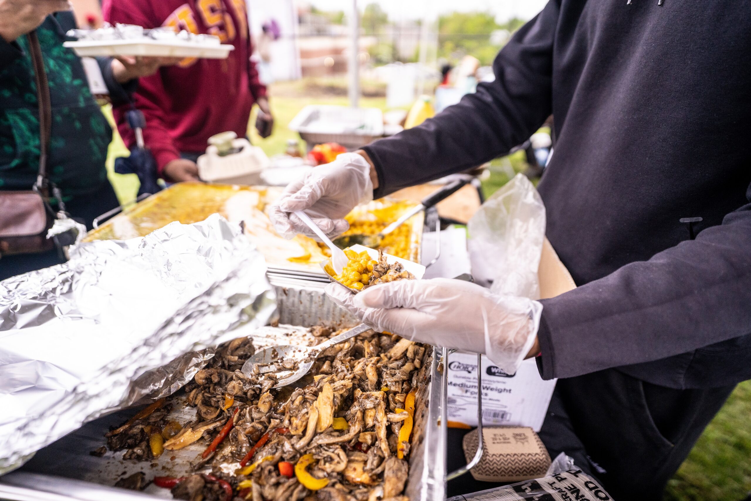 person serving cooked food at an event