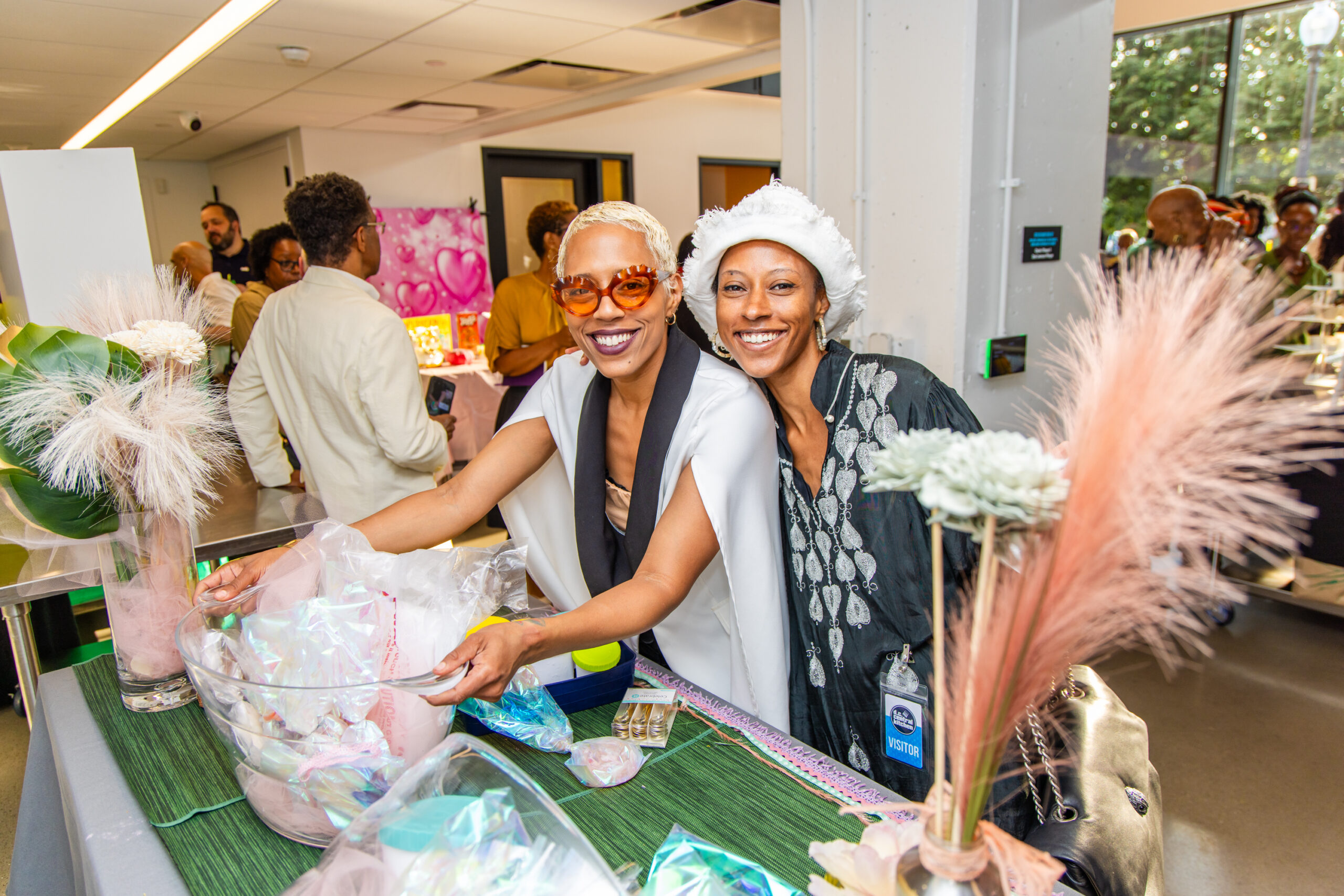 Two people standing at a table of promotional items and smiling